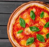 pizza margherita på svart trä bakgrund foto