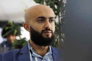 arab entreprenör lyssnande till marknadsföring strategi presentation i video ringa upp. Start upp företag verkställande chef arbetssätt på bärbar dator på finansiell Rapportera och ser på skärm foto