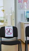 dental klinik reception med ingen i den modern utrustad med tecken på stolar för social distans under global pandemisk. tömma stomatologi reception med ny vanligt i covid-19 epidemi. foto