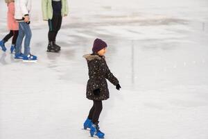 Tonårs flicka is skridskoåkning på rink utomhus foto