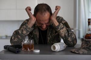 en man i kamouflage lider från depression efter återvändande från de armén. han användningar alkohol och narkotisk tabletter. han är Tormented förbi tung minnen. foto