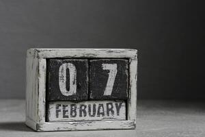 februari 07 på trä- kalender, på mörk grå bakgrund. foto