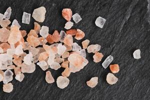 kristaller av rosa ätlig himalayan salt på bakgrund skiffer sten. foto