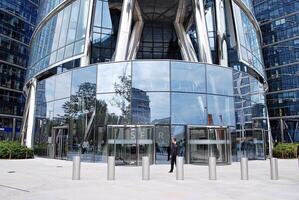 glas byggnad med transparent Fasad av de byggnad och blå himmel. strukturell glas vägg reflekterande blå himmel. abstrakt modern arkitektur fragment. samtida arkitektonisk bakgrund. foto