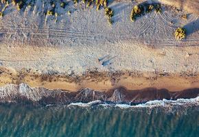 Flygfoto av en flicka med sin hund på en jungfrulig strand, i naturparken Punta Entinas, Almeria, Spanien foto