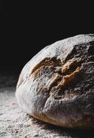 mörkt hembakat bröd pudrat med mjöl foto