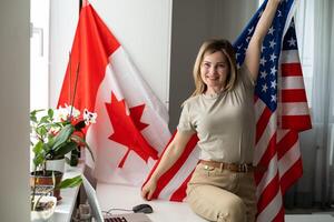 bild av Lycklig ung lady med USA flagga använder sig av bärbar dator dator. ser kamera. foto