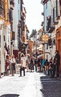 Granada, Spanien - 15 juni 2019 typiska restauranger och butiker på en gata i det populära gamla moriska kvarteret albaicin. den historiska stadskärnan i Granada. caldeleria gatan foto