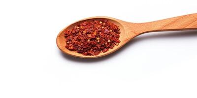 ai genererad chili peppar flingor i trä- sked på vit bakgrund. högen av krossad krydda paprika. lugg av krydda röd peppar flingor. topp se av kryddad krydda foto