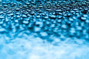 realistisk blå vatten droppar komprimerad för kreativ design på en glas. klar aqua droppar av annorlunda form ovan i de Foto och suddig nedan.makro skott