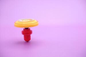 spinning topp leksak isolerat på lila bakgrund foto