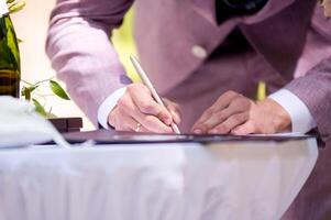 brudgum signering äktenskap licens. signatur ceremoni. bröllop tradition foto