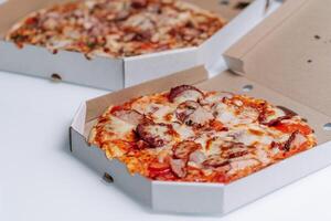 färsk tillverkad pizza i italiensk restaurang. traditionell italiensk pizza i kartong låda. foto