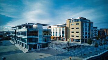 modern kontor byggnader med glas fasader under molnig himmel, tömma urban företag distrikt i skrov, england. foto