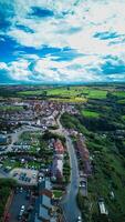 antenn se av en pittoresk stad med frodig grönska under en dynamisk himmel i staithes, england. foto