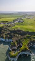 antenn se av en oländig kustlinje med grön fält och klippor utsikt en lugna hav i Flamborough, England foto