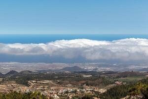 panorama- se av en kust landskap med moln svävande ovan och en klar blå himmel i teneriffa. foto
