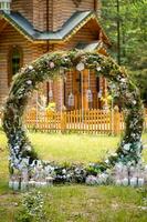 båge för de bröllop ceremoni. dekorerad med tyg blommor och grönska. foto