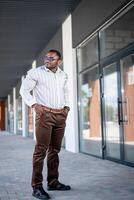 afrikansk man i vit skjorta och jeans stående foto