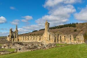 solig dag på gammal kloster ruiner med blå himmel och moln i yorkshire. foto