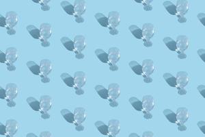glas med vatten och skugga mönster på blå bakgrund foto