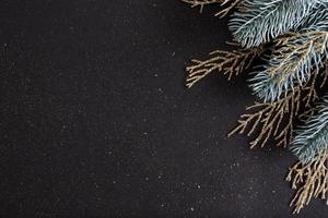 platt låg jul svart bakgrund dekorerad med nyår trädgrenar och glitter med kopia utrymme foto