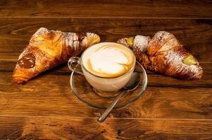 söta croissanter med grädde och cappuccino foto