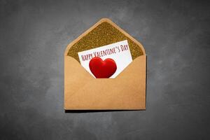 kuvert med papper inuti, med de text Lycklig valentines dag, på grå betong bakgrund foto