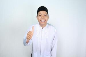 Lycklig muslim asiatisk man ger tummen upp isolerat på vit bakgrund foto