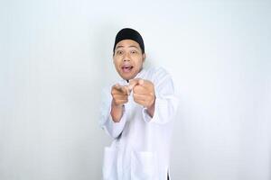 rolig asiatisk muslim man pekande hand framåt- med överraskad uttryck isolerat på vit bakgrund foto