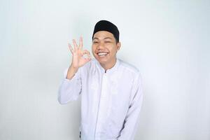 leende asiatisk man muslim visa ok tecken isolerat på vit bakgrund foto
