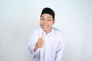 Lycklig muslim asiatisk man ger tummen upp isolerat på vit bakgrund foto