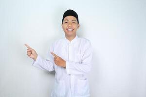 Lycklig muslim asiatisk man pekande till sida isolerat på vit bakgrund foto