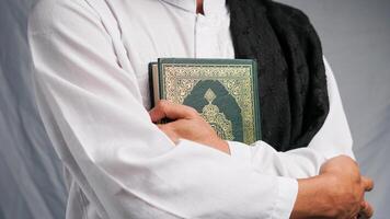 man kramas de quran med en bön pärlor i hans hand foto