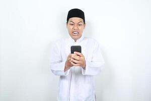 asiatisk muslim man visa arg uttryck medan ser på hans telefon foto