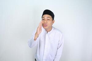 Lycklig muslim asiatisk man do viskande gest isolerat på vit bakgrund foto