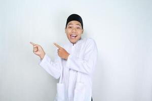 överraskad asiatisk muslim man pekande till kopia Plats isolerat på vit bakgrund foto