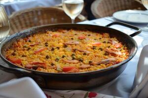 ai genererad traditionell spanska paella med skaldjur, kyckling, ris och grönsaker eras i en panorera foto