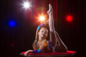 en flicka med en flexibel kropp. utför en cirkus konstnär. cirkus gymnast. balansering spela teater. de barn utför ett akrobatisk lura foto