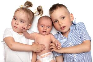 bror och syster lögn tillsammans med en nyfödd bebis. tre små barn av annorlunda åldrar. barn i de familj. foto