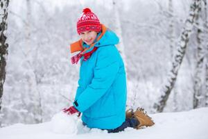 Lycklig liten pojke med en stor snö klot. Lycklig vinter- högtider begrepp. foto