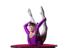 en flicka med en flexibel kropp. utför en cirkus konstnär. cirkus gymnast. balansering spela teater. de barn utför ett akrobatisk lura på en vit bakgrund foto