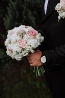 de brudgum är innehav ett elegant och skön bröllop bukett av vit och rosa blommor, närbild Foto. bröllop detaljer. hög kvalitet Foto