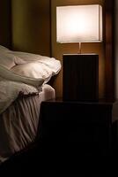 bedside lampa vänder på i sovrum på skymning. foto