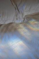 regnbåge ljus på de vit ark i de säng. foto