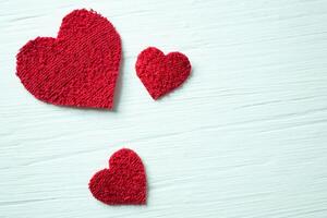 röd hjärtan på en vit texturerad tabell. foto