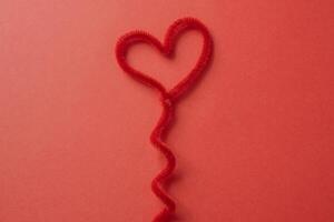 tråd hjärta på en röd bakgrund. foto