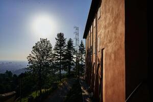 terrakotta vägg av en kyrka på en kulle i Italien med en se av bologna Nedan foto