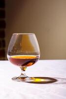 de lysa skarpt från de glas av franska brandy reflekterad på vit flik foto