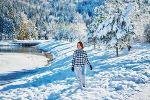 flicka spela med snö förbi de sjö i främre av bergen foto